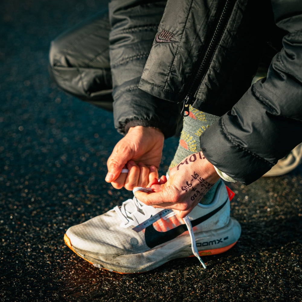 Ultrarunner Rachel Drake tying her shoelaces and wearing the Ray Day Darn Tough socks