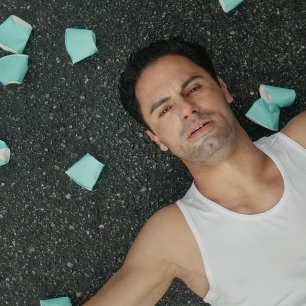 A runner collapsed on the ground surrounded by water cups