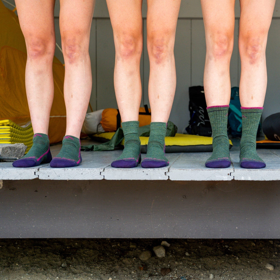 Three pairs of feet wearing different sock heights