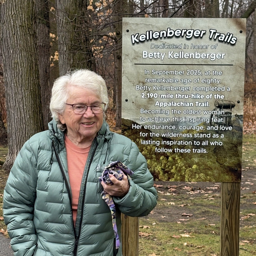 Betty Kellenberger, the oldest woman to hike the A.T., standing next to a sign dedicating a section of trail in her name.