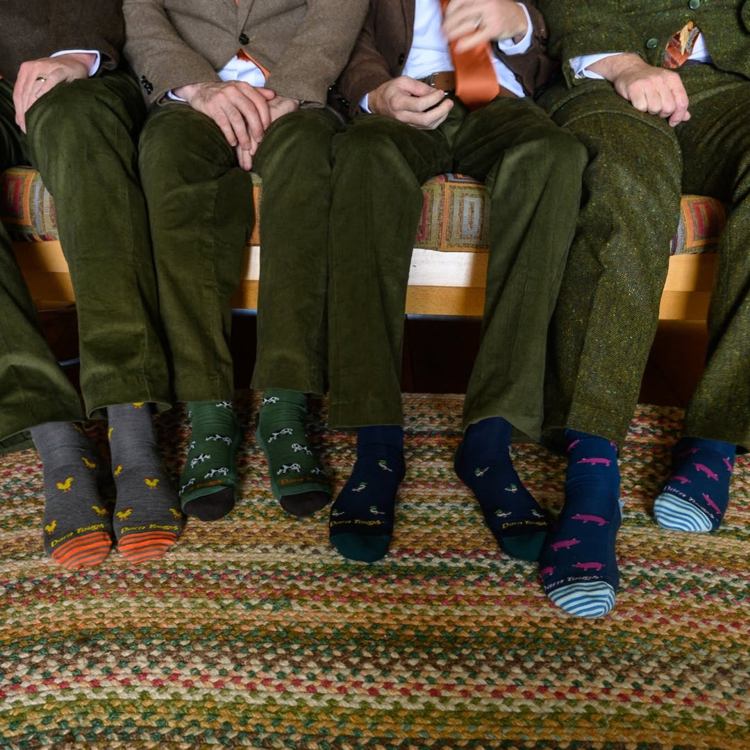 Four people sitting on a couch wearing warm winter dress socks.