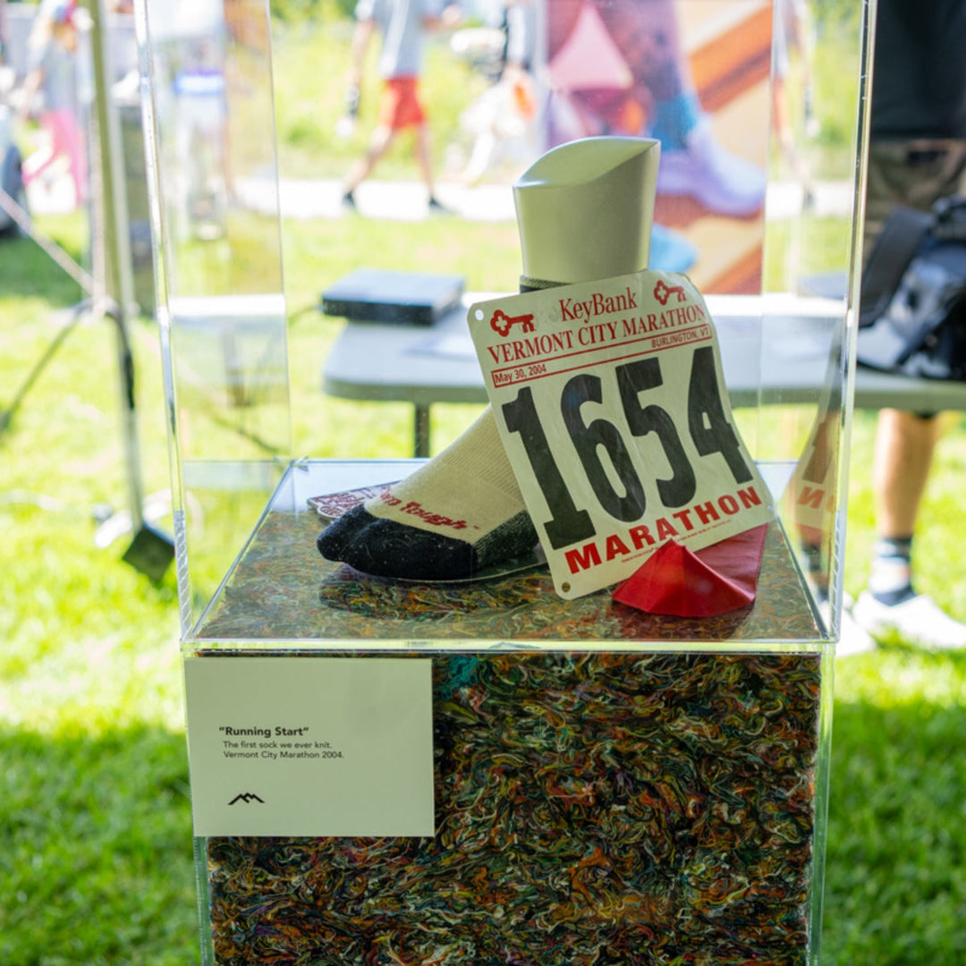 Darn Tough original running sock enclosed in glass case with Vermont City Marathon racing bib.