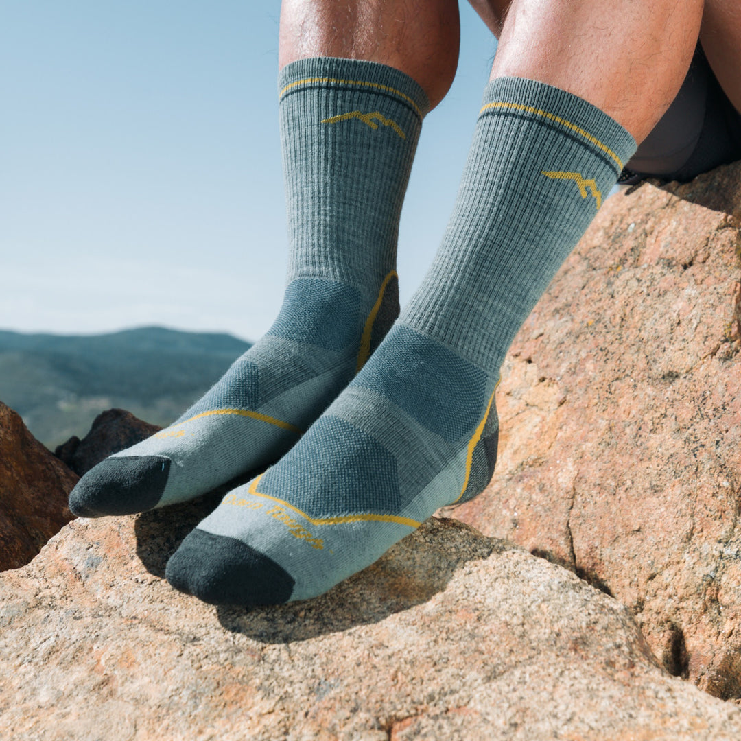close up models feet on mountain rock wearing the 5028 lightweight boot hiker in seafoam green colorway
