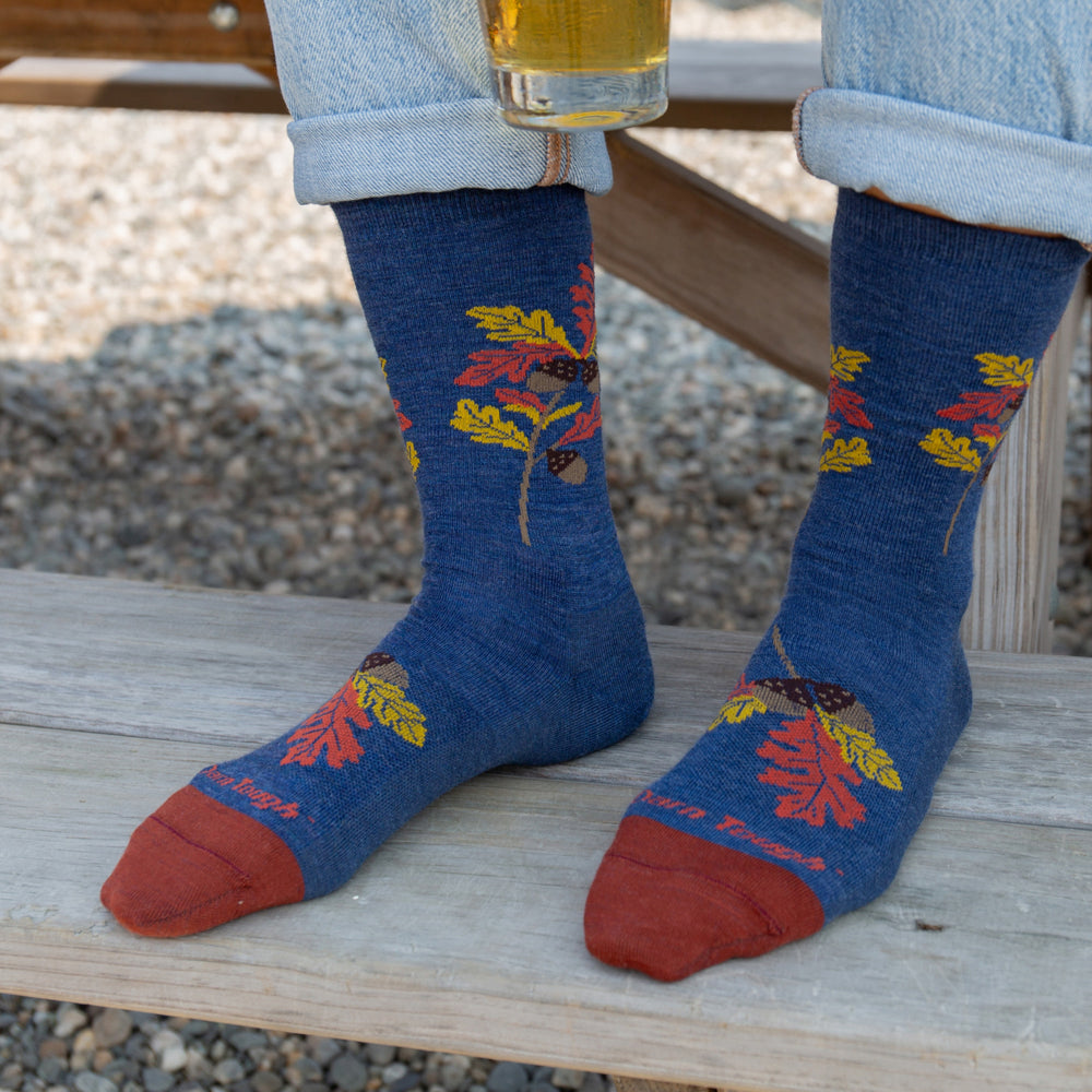 Model feet on wooden stair wearing the 6104 Blossom in oak denim featuring rust toe navy body and yellow/orange oak leaves on leg