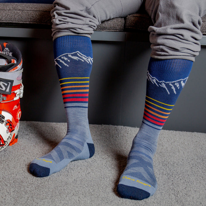 models feet on the carpet wearing the 8052 steep lines over the calf ski and snowboard sock in Eclipse