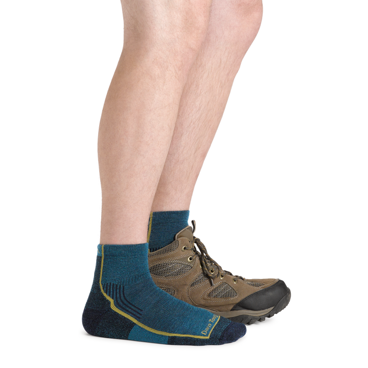  Model wearing Men's Hiker Quarter Midweight Hiking Socks in dark teal and a hiking boot on one foot