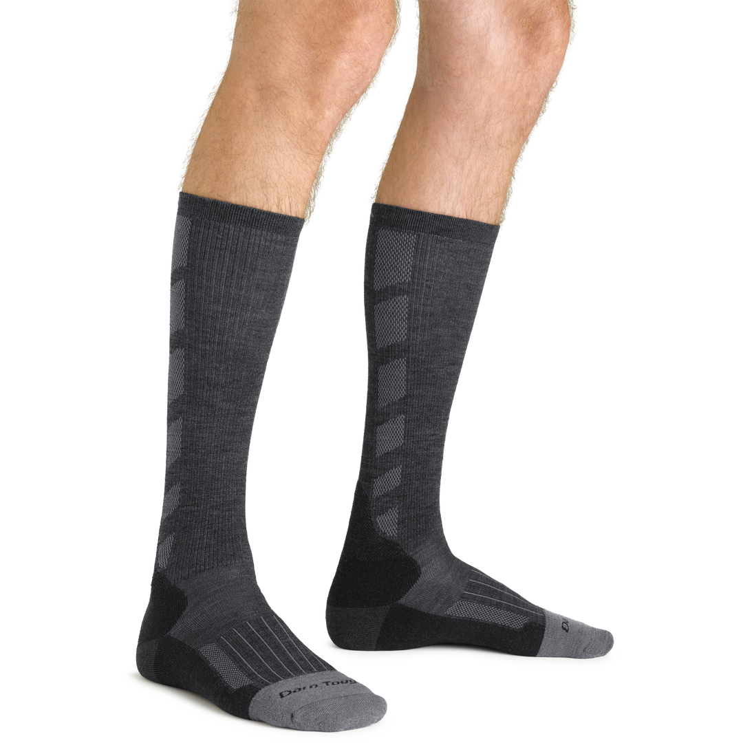 Close up studio shot of model wearing men's stanley k mid-calf lightweight work sock in gravel gray