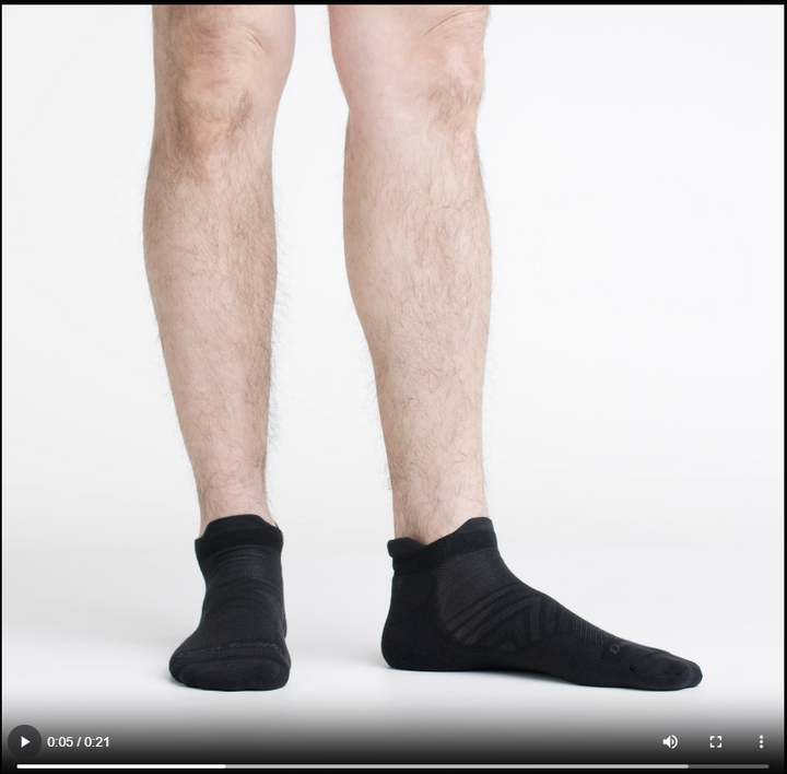 Video of model wearing no show tab running socks in black, showing a 360 degree view of socks.